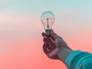 Persoon die gloeilamp vasthoudt als symbool voor SEO oplossingen